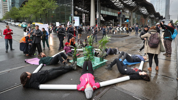 Extinction Rebellion protesters locked themselves together using plastic pipes to block Spencer and Collins streets..