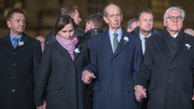 German President Frank-Walter Steinmeier, right, stands with dignitaries and guest including Britain's Duke of Kent, centre, in a human chain in Dresden.