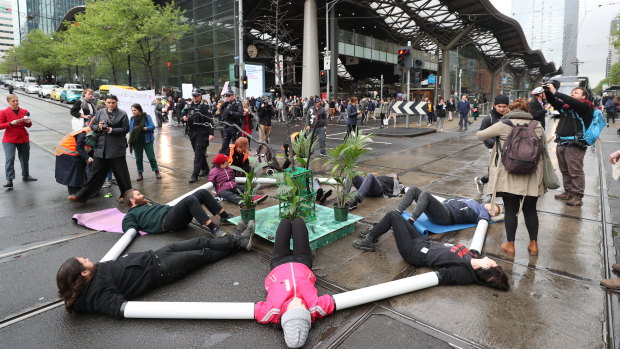 Protesters block the intersection at Collins and Spencer streets.