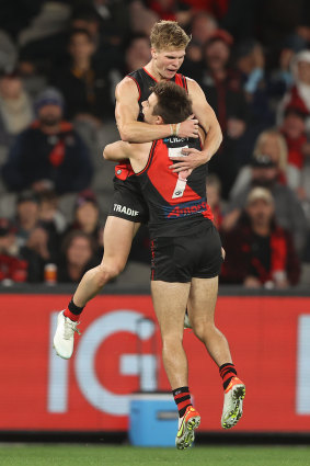 Ben Hobbs celebrates with Bombers teammate Zach Merrett.