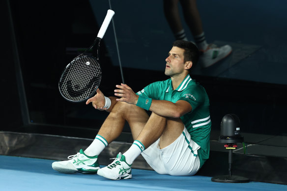 Novak Djokovic, one of several players struggling with injury, sits down on the court during his match against Alexander Zverev.