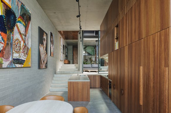 The kitchen, above the living area, includes a concrete bench as a landing platform between levels.
