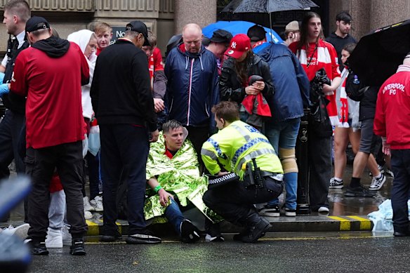 A police officer speaks with an injured man at the scene.
