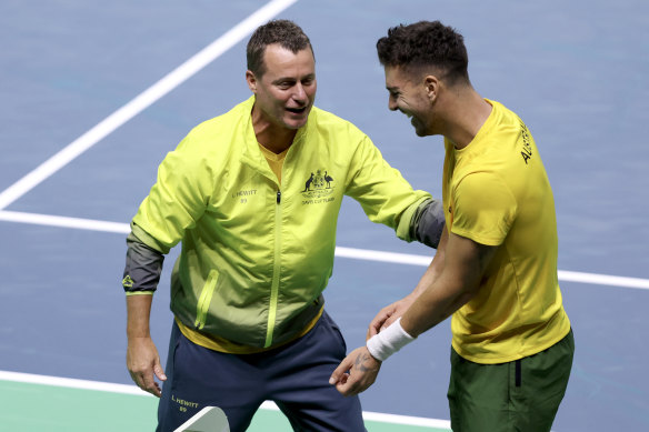 Kokkinakis celebrates with Australia Team Captain Lleyton Hewitt after winning his singles match against Ben Shelton.