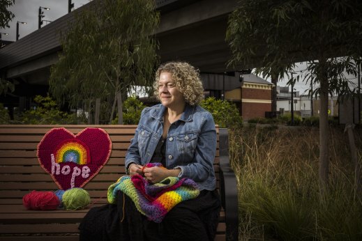 Lifting spirits: Veneta Cue with one of her yarn bombing crochet pieces near Moreland railway station in Coburg.