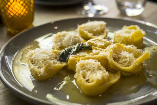 Plump, cheese-filled tortelloni are nestled on a butter and sage sauce.