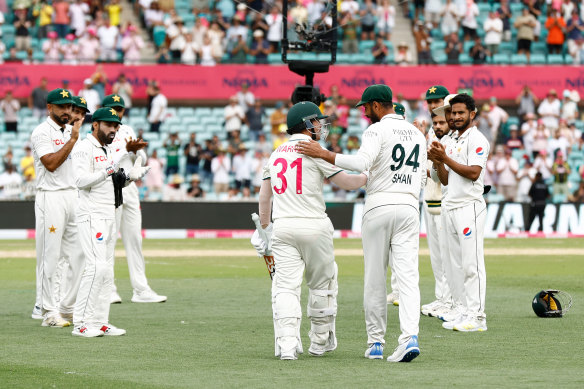 Pakistan captain Shan Masood congratulates David Warner before his last innings.