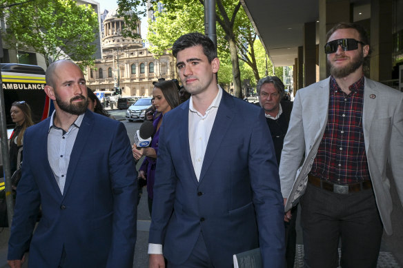 Hersant, middle, and supporter Thomas Sewell, left, leave court.