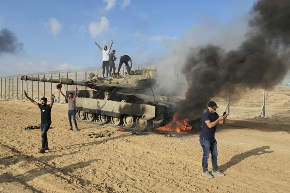 Palestinians celebrate destroying an Israeli tank.