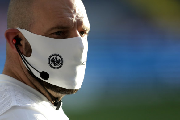 A member of Frankfurt's coaching staff wears a mask on the sidelines.