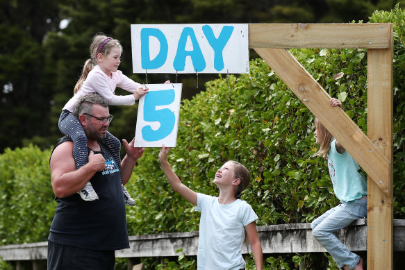 The Paddisons update their roadside isolation countdown sign in Kaipara Flats, Auckland, on Tuesday.