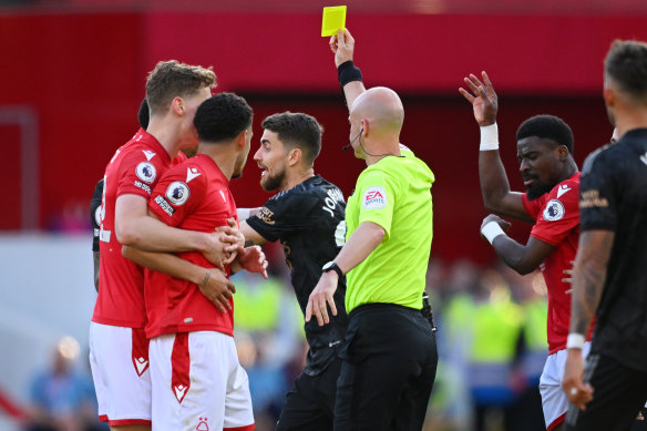 The referee shows a yellow card to Jorginho of Arsenal during the loss to Nottingham Forest.