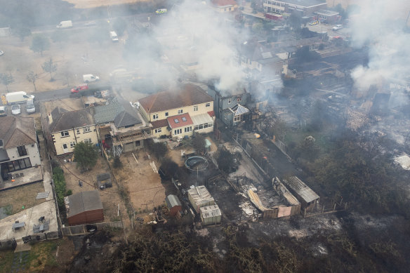 In this aerial view, smoke from fires in a residential area being fought by fire services are seen on July 19, 2022, in Wennington, England.