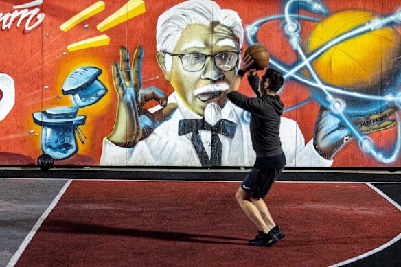 A man plays basketball on a court sponsored by American fast food chain KFC.