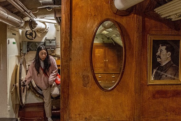 A Chinese tourist passes a portrait of Stalin onboard a replica Soviet submarine.