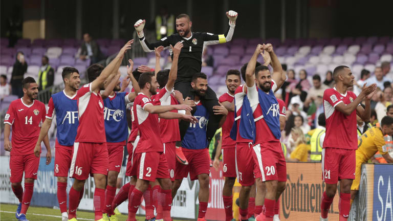 Huge result: Jordan's goalkeeper Amer Shafi, top, and his teammates celebrate their huge upset over the Socceroos.