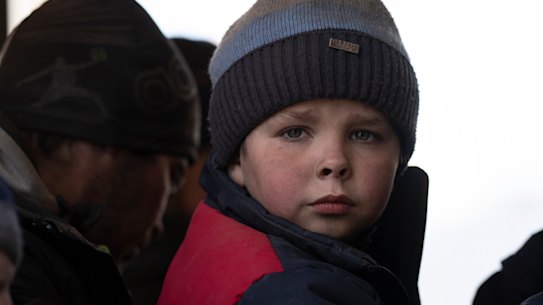 A child looks out of a damaged bus as he and other displaced people arrive at the Ukrainian Red Cross centre in Mykolaiv, southern Ukraine,  last year.