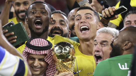 Al Nassr’s Cristiano Ronaldo, and teammates celebrate with the trophy of the Arab Club Championship Cup.