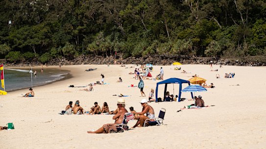 Beach-goers enjoying the sun and sand at Noosa last month.