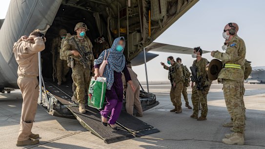 Afghanistan evacuees and Australian soldiers disembark a Royal Australian Air Force C-130J Hercules aircraft at Australia’s main operating base in the Middle East, after their flight from Kabul.