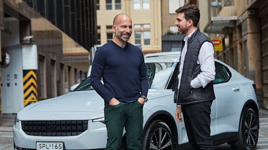 Uber chief executive Dara Khosrowshahi speaks with the chief executive of car finance firm Splend, Chris King, in front of one of the cars the two companies will lease to drivers.