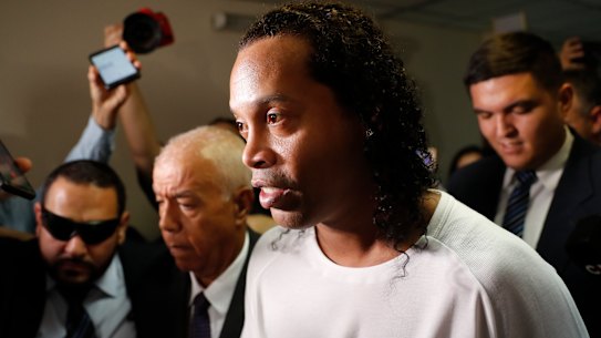 Former soccer star Ronaldinho is escorted by police to go before Judge Mirko Valinotti at the Justice Palace court in Asuncion, Paraguay, Friday, March 6, 2020.  Ronaldinho has been detained by Paraguayan police for allegedly entering the country with a falsified passport. (AP Photo/Jorge Saenz)