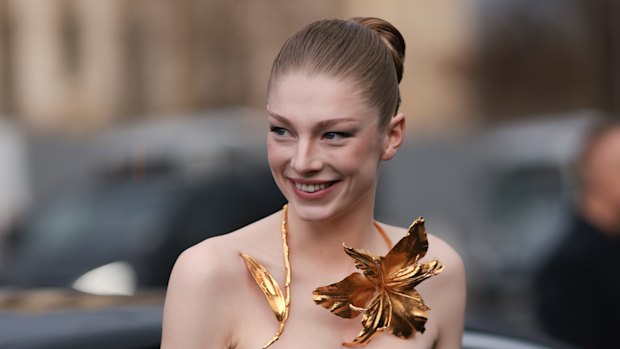 Hunter Schafer’s slicked-back bun highlighted her bold gilded jewellery at a recent Schiaparelli haute couture show.