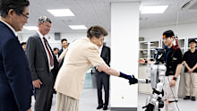 Princess Anne shakes hands with a robot in South Korea.