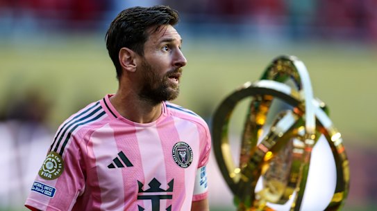 Lionel Messi and the FIFA Club World Cup trophy.