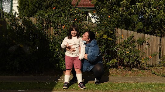 Maria Moschetti embraces her 6 year old daughter Lily Thomson, who has autism. They’ve been trying to bring joy to their neighbours where they can.