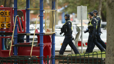 A police patrol walks past a playground in Melbourne.