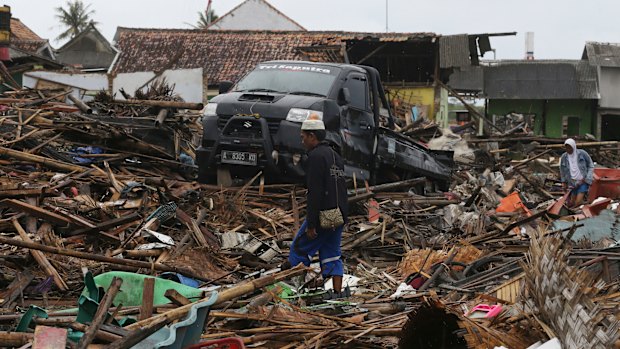 A tsunami survivor walks at a tsunami-ravaged village in Sumur, Indonesia.