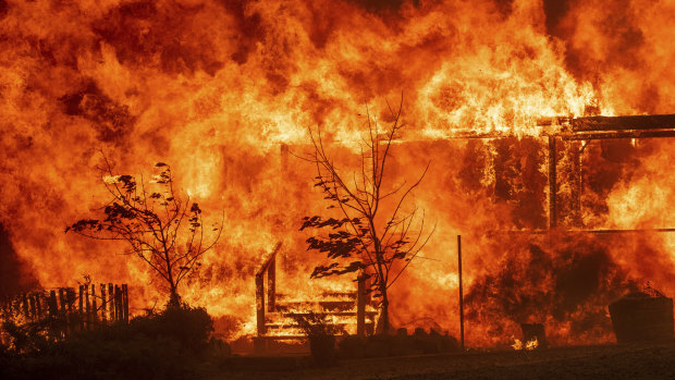 Flames consume a home as the River Fire tears though Lakeport, California on Tuesday.