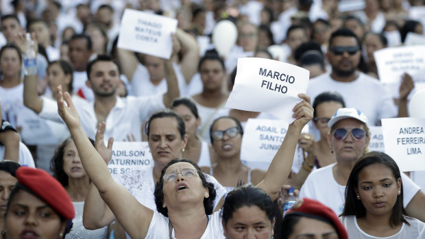 Friends and relatives hold signs with the names of victims of the Vale mining dam collapse during a march in Brumadinho.