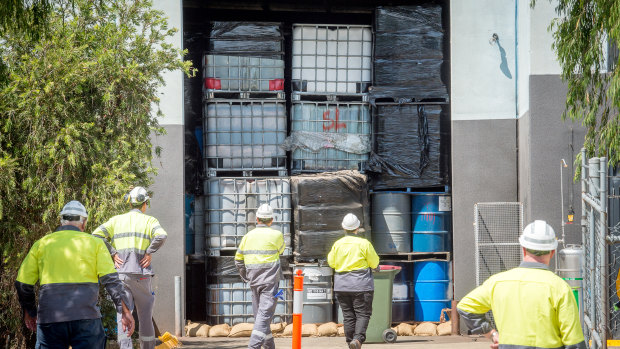 Workers inspect the stockpile of toxic chemicals at the Epping warehouse on Wednesday. 