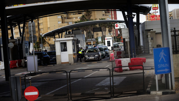 A Gibraltarian police officer talks with the driver of a car crossing the border of Spain with Gibraltar.