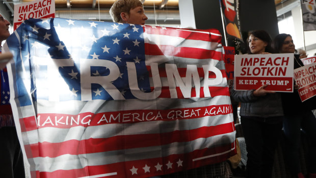Waving the flag proudly: Donald Trump supporters gather before US Representative Elissa Slotkin holds a constituent community conversation at Oakland University in Michigan. Slotkin said she will vote to impeach Trump