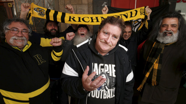 Leigh McCulloch (centre) was surrounded by Richmond fans in line for preliminary finals tickets at Ticketek on Exhibition Street on Sunday. 