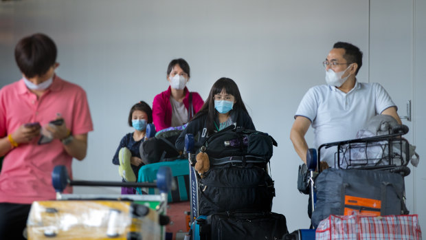 Visitors arrive at Melbourne Airport in wearing face masks. 
