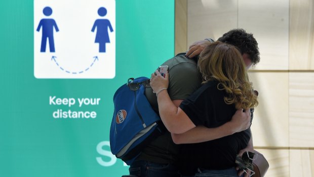 Nathan greets his partner moments after he arrives at the Sydney International Airport. 