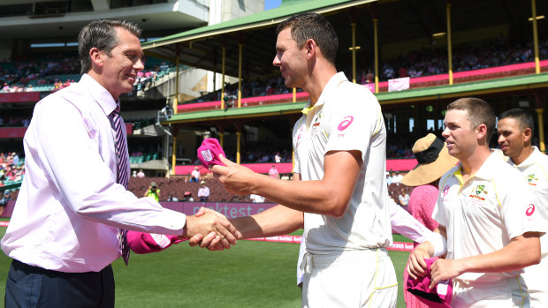 Glenn McGrath presents Josh Hazlewood and the Australian players with special caps for the Pink Test, which raise funds for the McGrath Foundation.