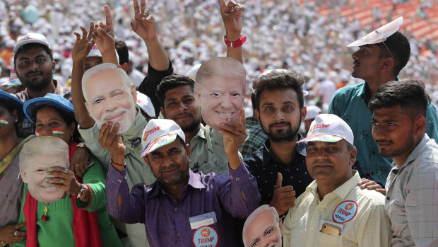 Indians hold masks of US President Donald Trump and Indian Prime Minister Narendra Modi as they wait for the Namaste Trump event at Sardar Patel Stadium in Ahmedabad on Monday.