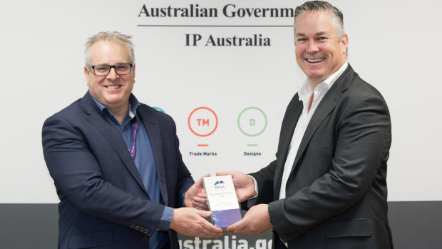 IP Australia general manager Robert Bollard receiving the award from Pegasystems's Luke McCormack. 