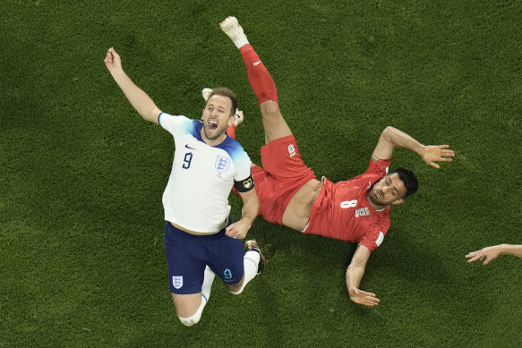 England captain Harry Kane, fouled here by Iran’s Morteza Pouraliganji, wore a FIFA-approved armband rather than the inclusive OneLove armband after the governing body threatened to sanction captains who carried the LGBTQ messaging.