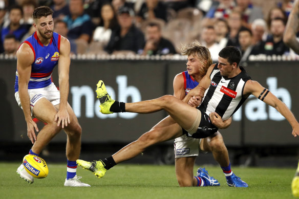 Scott Pendlebury is tackled by Bailey Smith in their opening-round clash.