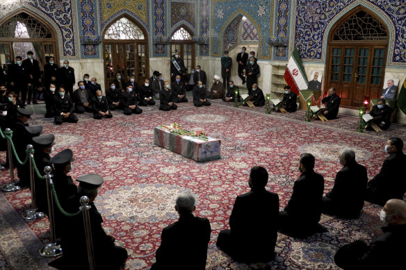 People pray over the flag draped coffin of Mohsen Fakhrizadeh.