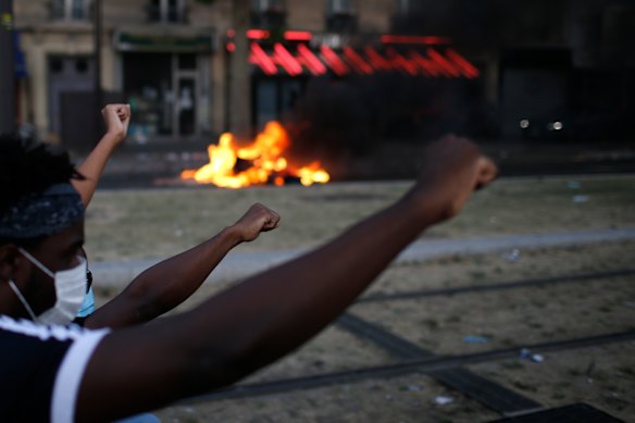 Protesters raise their fists during an unauthorised demonstration against police violence and racial injustice in Paris on Tuesday.