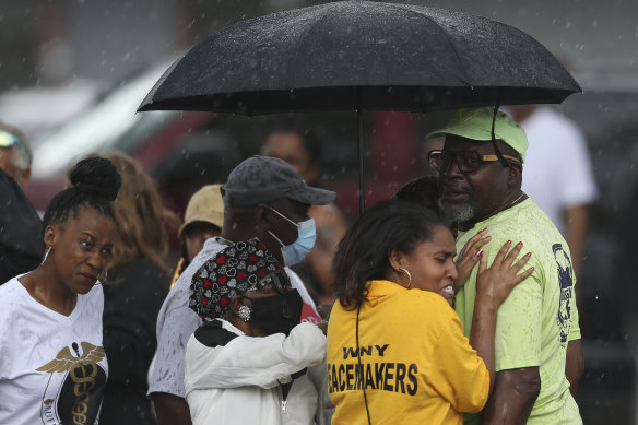 Bystanders gather after a shooting at a supermarket on Saturday, May 14, 2022, in Buffalo, N.Y.  Officials said the gunman entered the supermarket with a rifle and opened fire. 