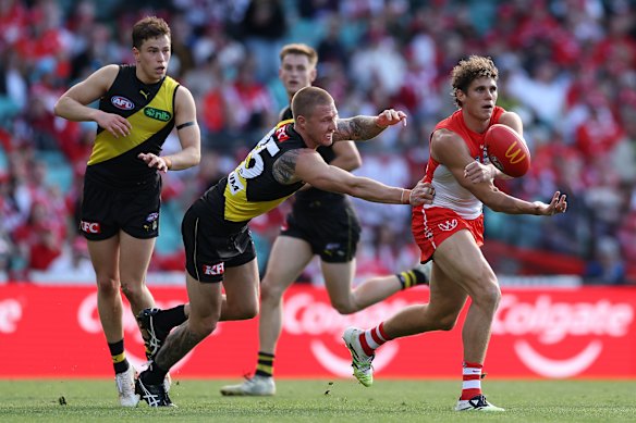 Charlie Curnow handballs against a stretched Tigers side.