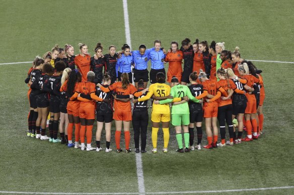 Players and officials from the NWSL’s Portland Thorns and Houston Dash pause for a minute of solidarity during a match last October.